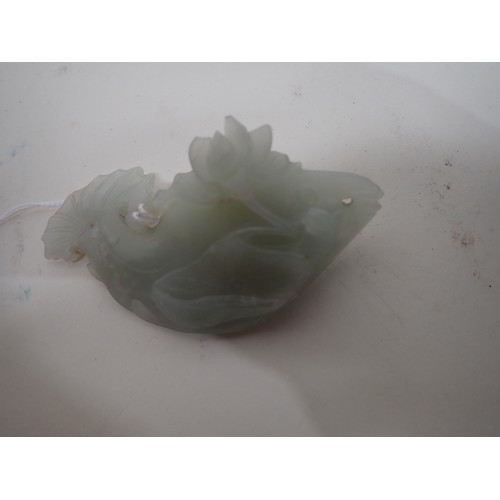 413 - A Chinese celadon Jade carved Fish with lily pad and flower to one side, small chips, on hardwood st... 