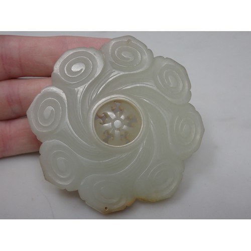 412 - A Chinese celadon Jade Bi Disk carved flower head with geometric carved centre section on hardwood s... 