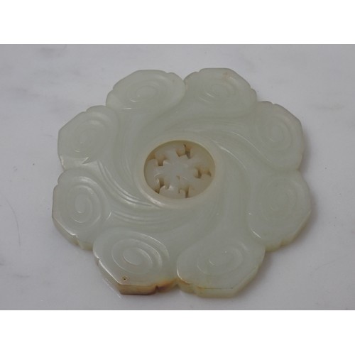 412 - A Chinese celadon Jade Bi Disk carved flower head with geometric carved centre section on hardwood s... 