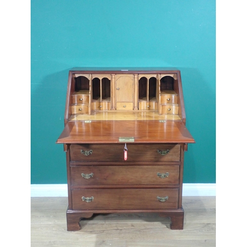 1 - A reproduction mahogany Bureau with fitted oak interior above two short and three long drawers on br... 