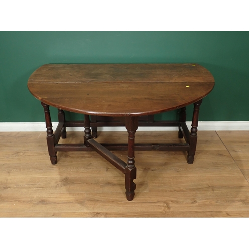 16 - An antique oak Gateleg Table with oval top, fitted frieze drawer on turned supports and squared stre... 