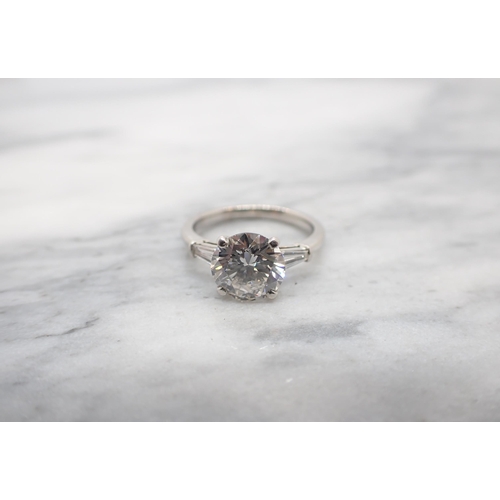 173 - A Diamond Ring claw-set brilliant-cut stone, 2.09cts, between two tapered baguettes in platinum, rin... 