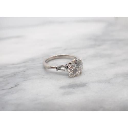 173 - A Diamond Ring claw-set brilliant-cut stone, 2.09cts, between two tapered baguettes in platinum, rin... 