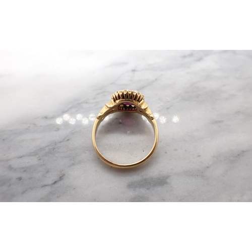 175 - A Garnet and Seed Pearl cluster Ring pavé-set cushion-cut garnet within a frame of seed pearls in 18... 