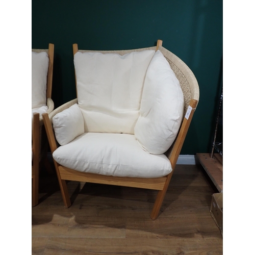 291 - A pair of asymmetrical Armchairs with cane work panels and upholstered cushions