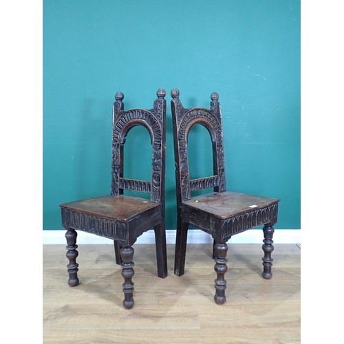 305 - A pair of carved oak Chairs with arched backs carved figures on turned supports