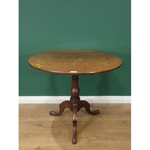 323 - An circular oak tilt top Tripod Table on turned column and splayed supports, 2ft 5