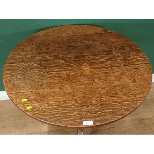 323 - An circular oak tilt top Tripod Table on turned column and splayed supports, 2ft 5