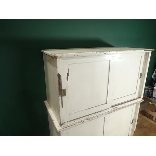 394 - A white painted pine Cupboard with two pairs of sliding doors on plinth base, 5ft H x 4ft 2in W