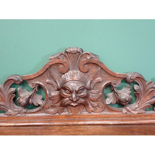 397 - A large carved oak Buffet, the upper tier fitted two drawers above a carved green man carving flanke... 