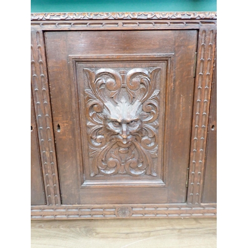 397 - A large carved oak Buffet, the upper tier fitted two drawers above a carved green man carving flanke... 