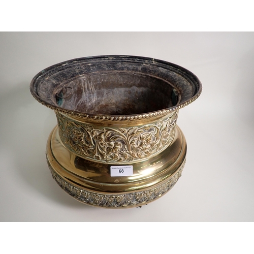 68 - A circular brass Jardiniere with gadroon rim, floral scroll and leafage embossed friezes on paw feet... 