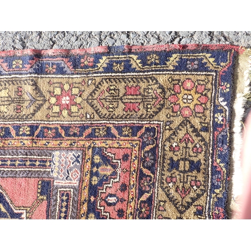 71 - A bordered Persian large Rug with stepped medallion containing stars, etc, on a brick red and blue g... 