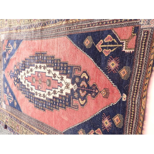 71 - A bordered Persian large Rug with stepped medallion containing stars, etc, on a brick red and blue g... 