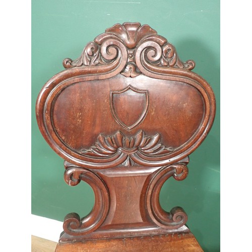 385 - A pair of 19th Century mahogany Hall Chairs with carved and shaped backs and raised on reeded taperi... 