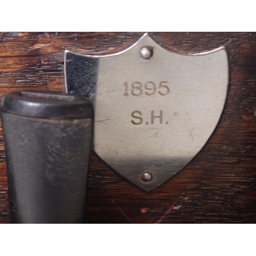 105 - An oak, six bay hanging Pipe Rack with white metal shield dated 1895, along with six briar pipes