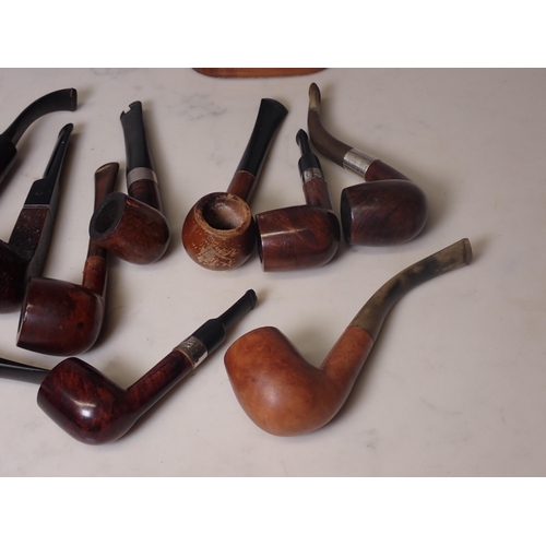 107 - A bundle of 12 briar pipes, some with white metal collars, and a 2 bay pipe stand