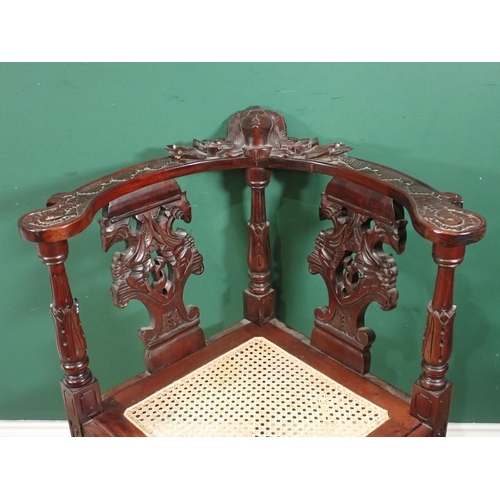 124 - A carved mahogany Corner Chair with cane seat and an oak Sutherland Table