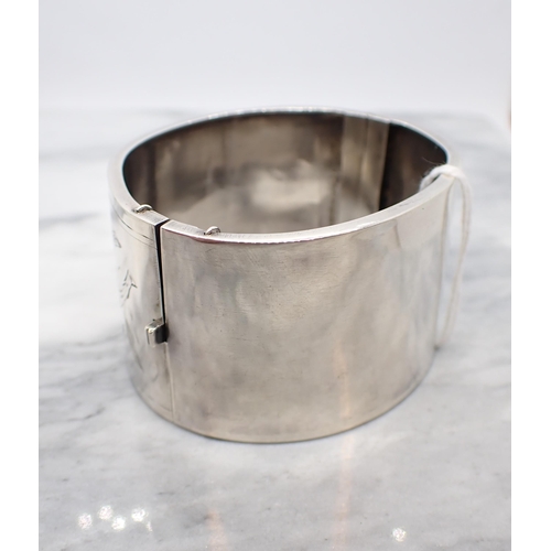 168 - A silver hinged Cuff Bangle with floral bright-cut engraving to front, marked Sterling