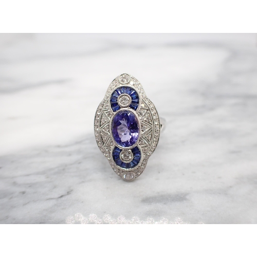 183 - An Art Deco style Tanzanite, Sapphire and Diamond Cocktail Ring millegrain-set oval-cut tanzanite be... 