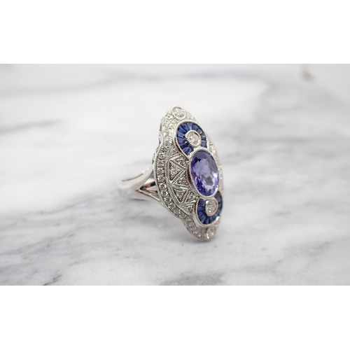 183 - An Art Deco style Tanzanite, Sapphire and Diamond Cocktail Ring millegrain-set oval-cut tanzanite be... 