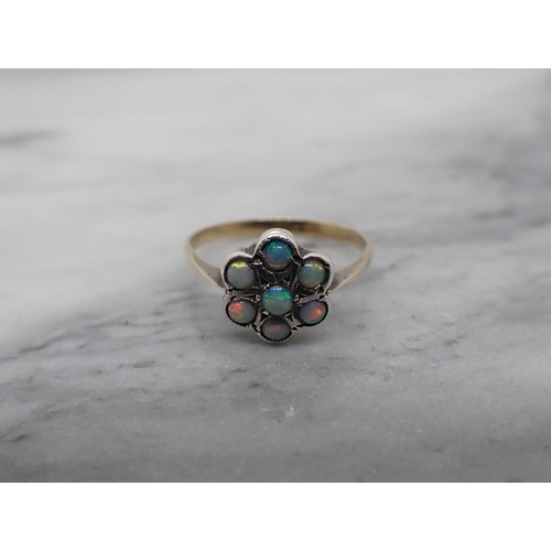 200 - An Opal Daisy Cluster Ring set seven round stones, stamped 9ct and SIL, ring size L