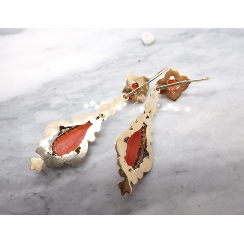 204 - A pair of carved Coral Cameo Ear Pendants each within intricate yellow metal mount