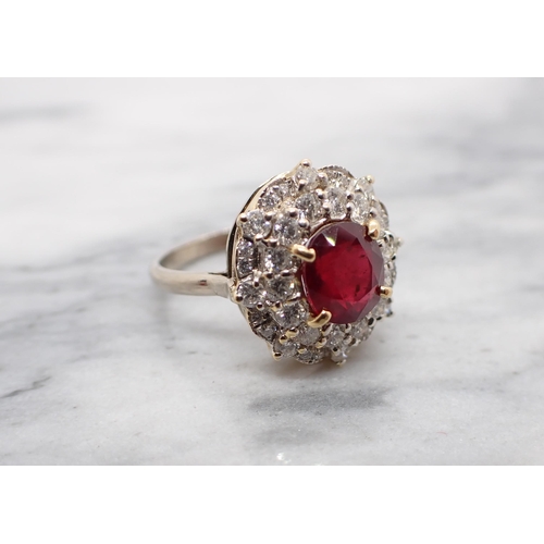 214 - A treated Ruby and Diamond Cluster Ring claw-set oval-cut treated ruby within double frame of brilli... 