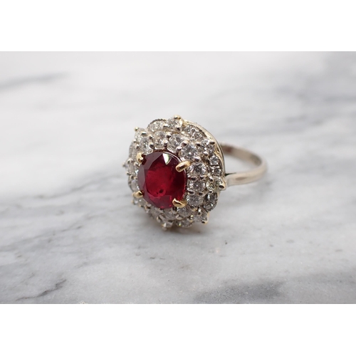 214 - A treated Ruby and Diamond Cluster Ring claw-set oval-cut treated ruby within double frame of brilli... 