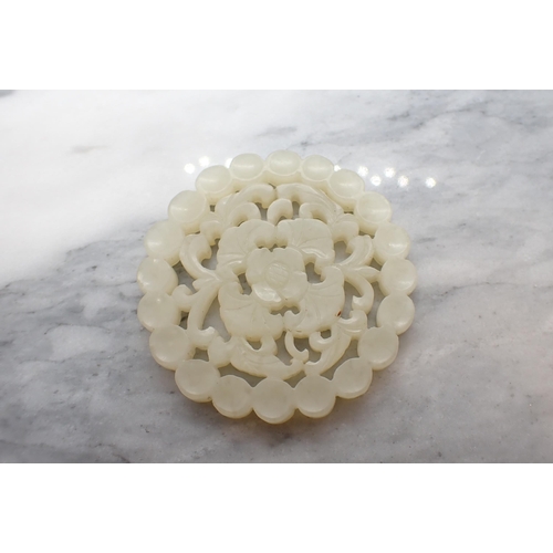 222 - A jade type carved and pierced flowerhead Disc, 5.5cms diameter