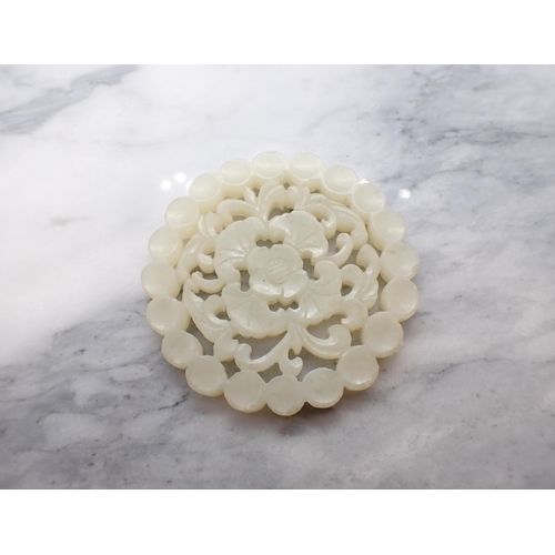 222 - A jade type carved and pierced flowerhead Disc, 5.5cms diameter