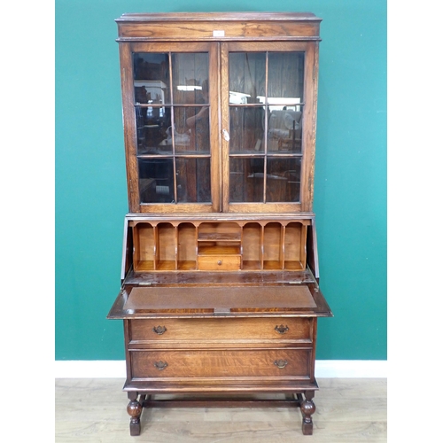 30 - An oak Bureau Bookcase fitted pair of glazed doors enclosing adjustable shelves above three drawers ... 