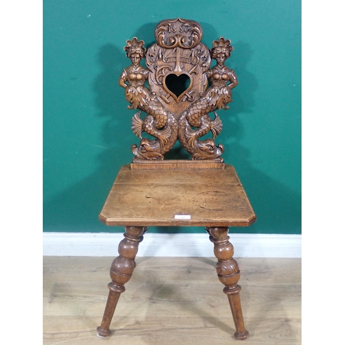 374 - An oak Hall Chair from the French Elzas region with heart pierced back flanked by mermaids dated 188... 