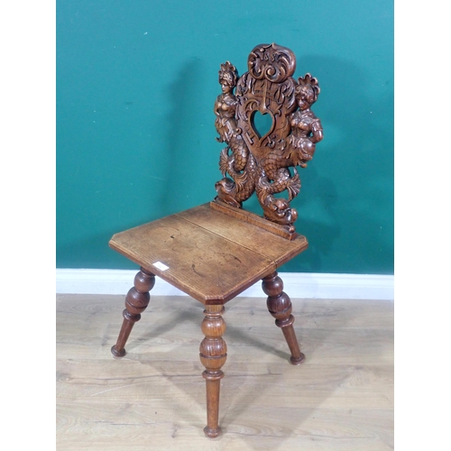 374 - An oak Hall Chair from the French Elzas region with heart pierced back flanked by mermaids dated 188... 