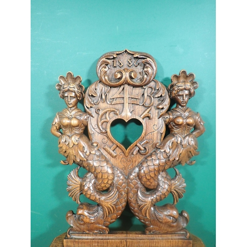 374 - An oak Hall Chair from the French Elzas region with heart pierced back flanked by mermaids dated 188... 