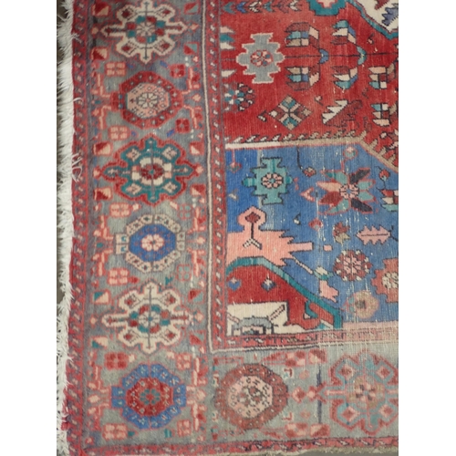 665 - A Persian Rug with bands of blue, red and cream ground decorated stylised flowers within border with... 