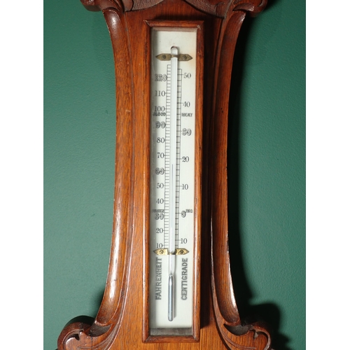 97 - An oak cased Aneroid Barometer and Thermometer with white enamel circular dial, inscribed H. Hughes ... 