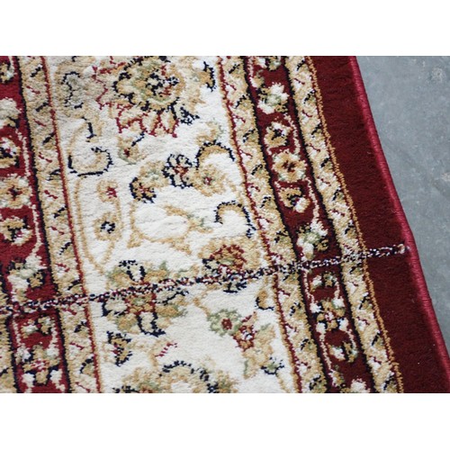 397 - A Dunelm Rug with floral design on a red ground, 7ft 6in x 5ft 3in