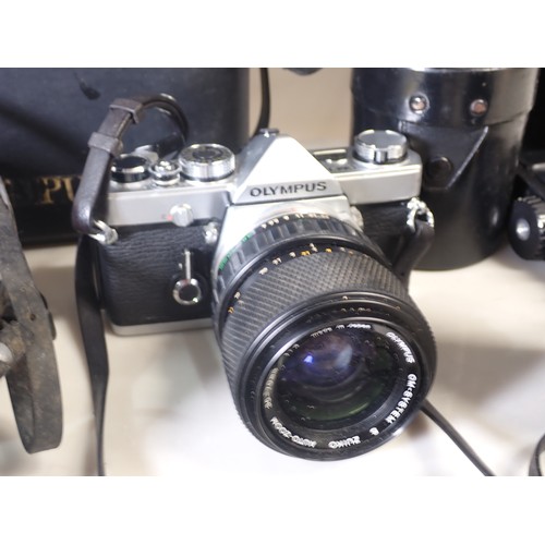 442 - A Canon FX 35mm Camera, an Olympus 35mm Camera, a quantity of Lenses, Cine type Camera, a Students M... 