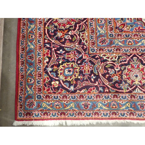 497 - A large Persian style Carpet with multiple borders and central floral medallion on a red ground, 13f... 