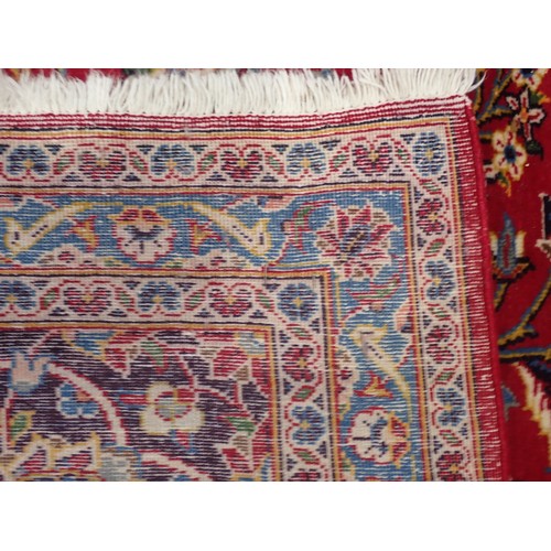 497 - A large Persian style Carpet with multiple borders and central floral medallion on a red ground, 13f... 