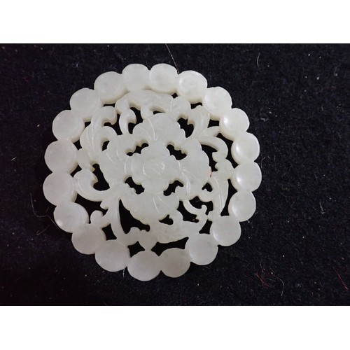 222 - A jade type carved and pierced flowerhead Disc, 5.5cms diameter