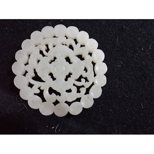 222 - A jade type carved and pierced flowerhead Disc, 5.5cms diameter