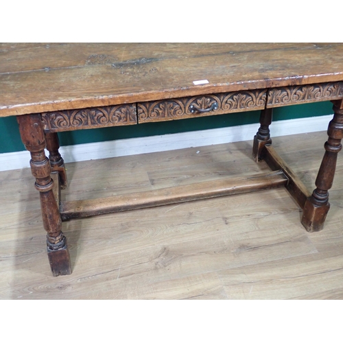 313 - An oak Refectory Table in the 17th Century style with cleated three plank lid and leafage carved fri... 