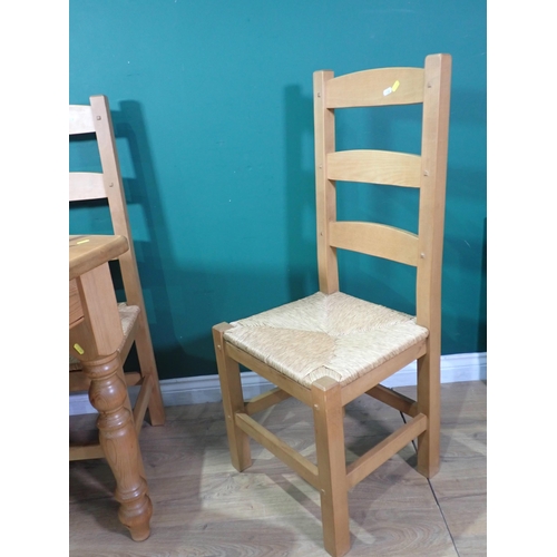 338 - A modern pine Kitchen Table on turned supports 4ft W x 2ft 6in H and four rush seated Kitchen Chairs