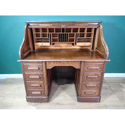 69 - An oak Roll-top Desk, the tambour enclosing drawers and pigeon holes above nine drawers to base 4ft ... 