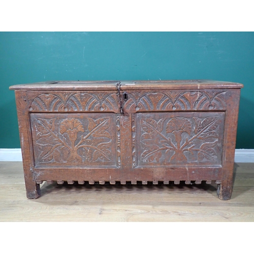 70 - A 17th Century oak Coffer with sunken two panel lid above leafage carved two panel front mounted on ... 