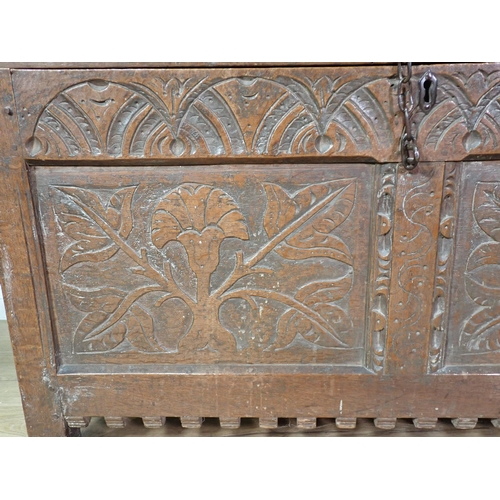 70 - A 17th Century oak Coffer with sunken two panel lid above leafage carved two panel front mounted on ... 