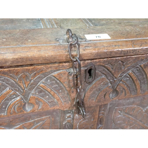 70 - A 17th Century oak Coffer with sunken two panel lid above leafage carved two panel front mounted on ... 