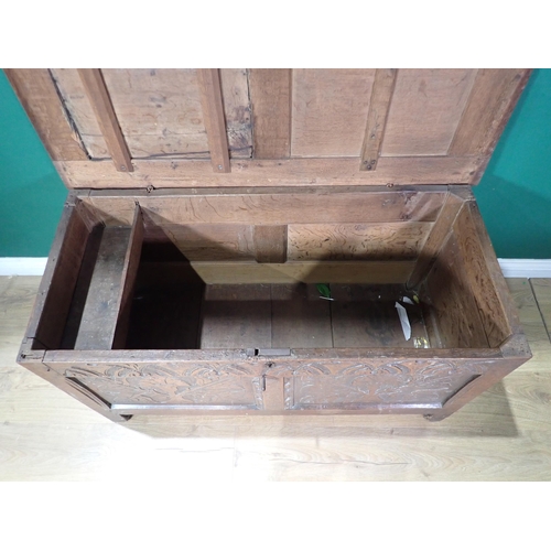 70 - A 17th Century oak Coffer with sunken two panel lid above leafage carved two panel front mounted on ... 